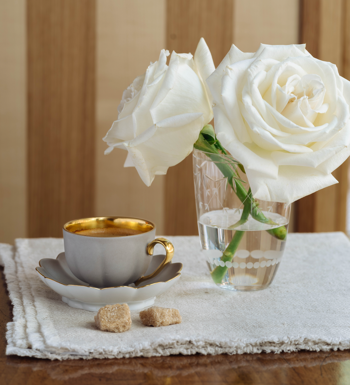 Melon Espresso Cup of Augarten Wien on a napkin, with two sugar cubes, next to a Lobmeyr etched glass holding white roses for Lakeview Home